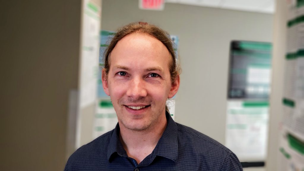 Man with pony tail smiling