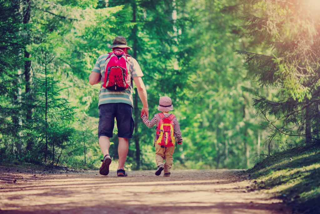 Father And Boy Going Camping With Tent In Nature