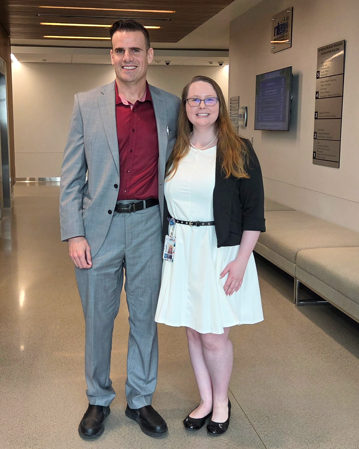 Two individuals standing together in a hallway