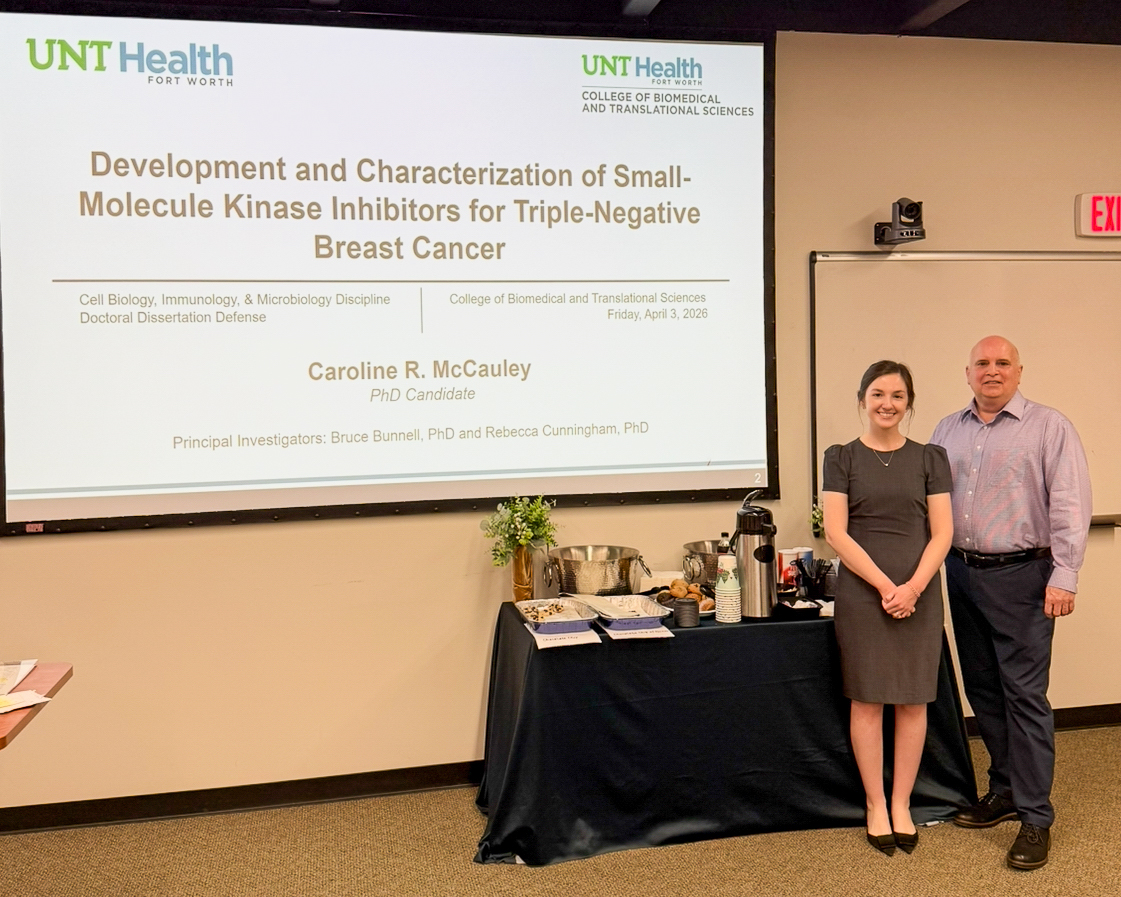 Student and Faculty Member standing in front of a screen with powpoint slide displayed