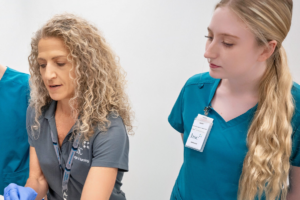 Photo of an instructor and student during a lesson bedside in the simulation center