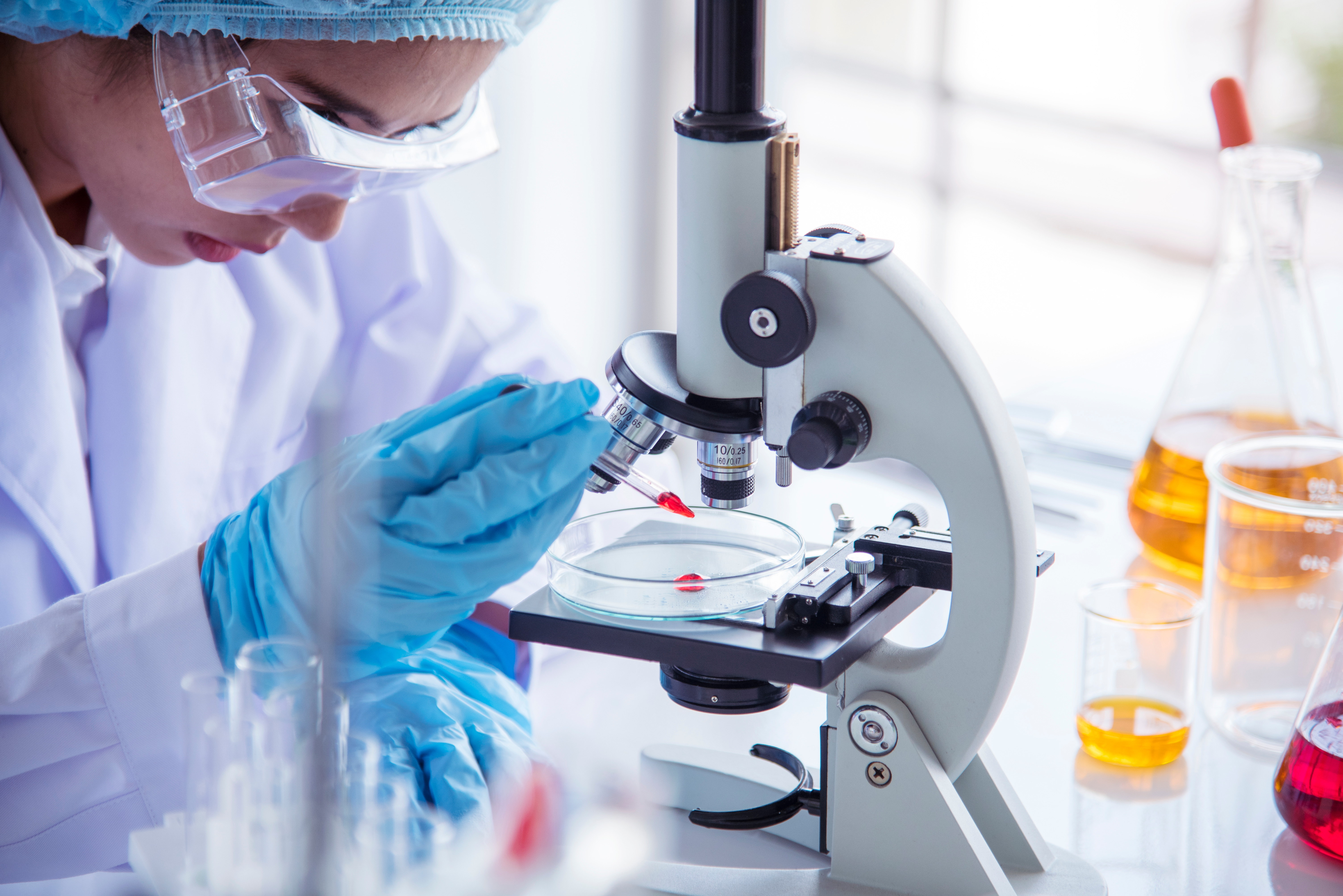 scientist looking through microscope