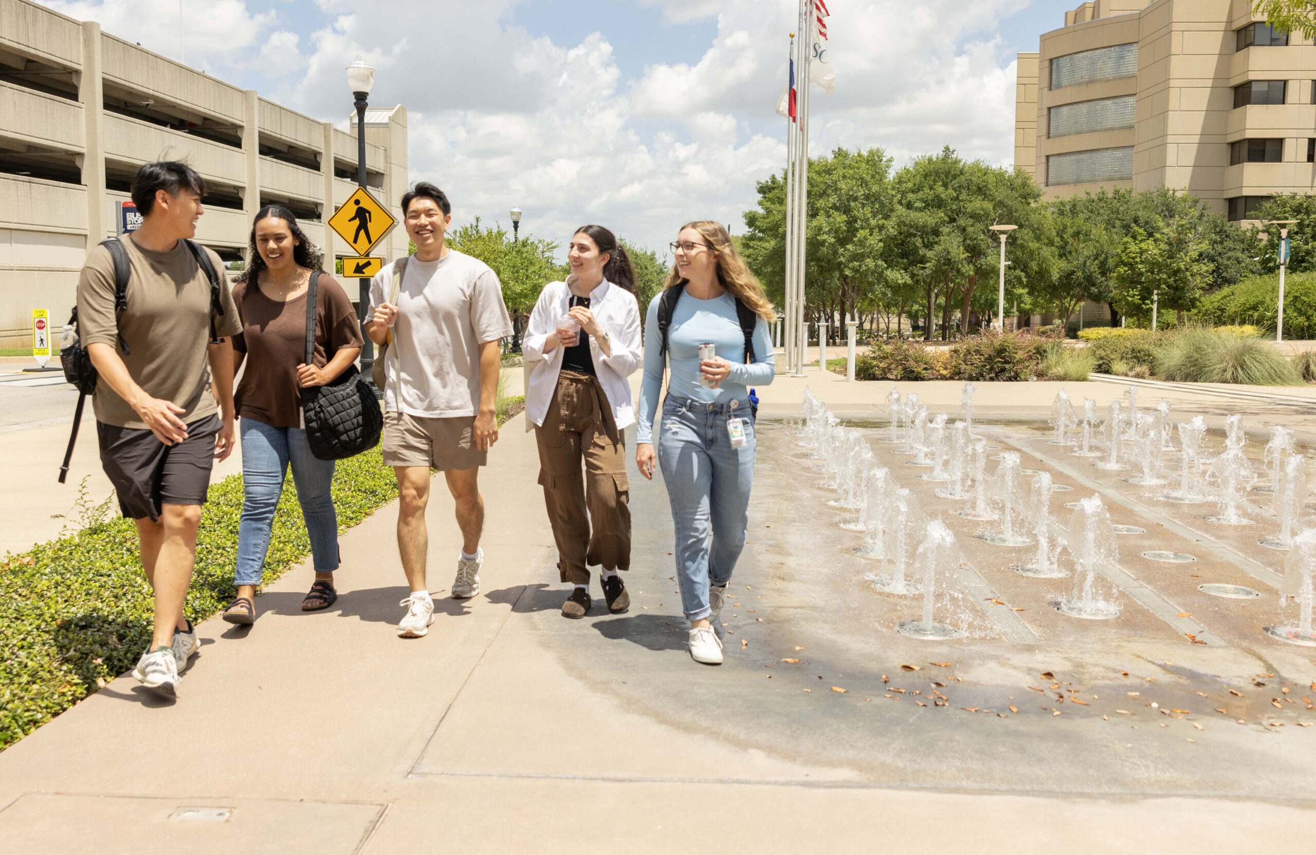 Group of students walking near a waterfall